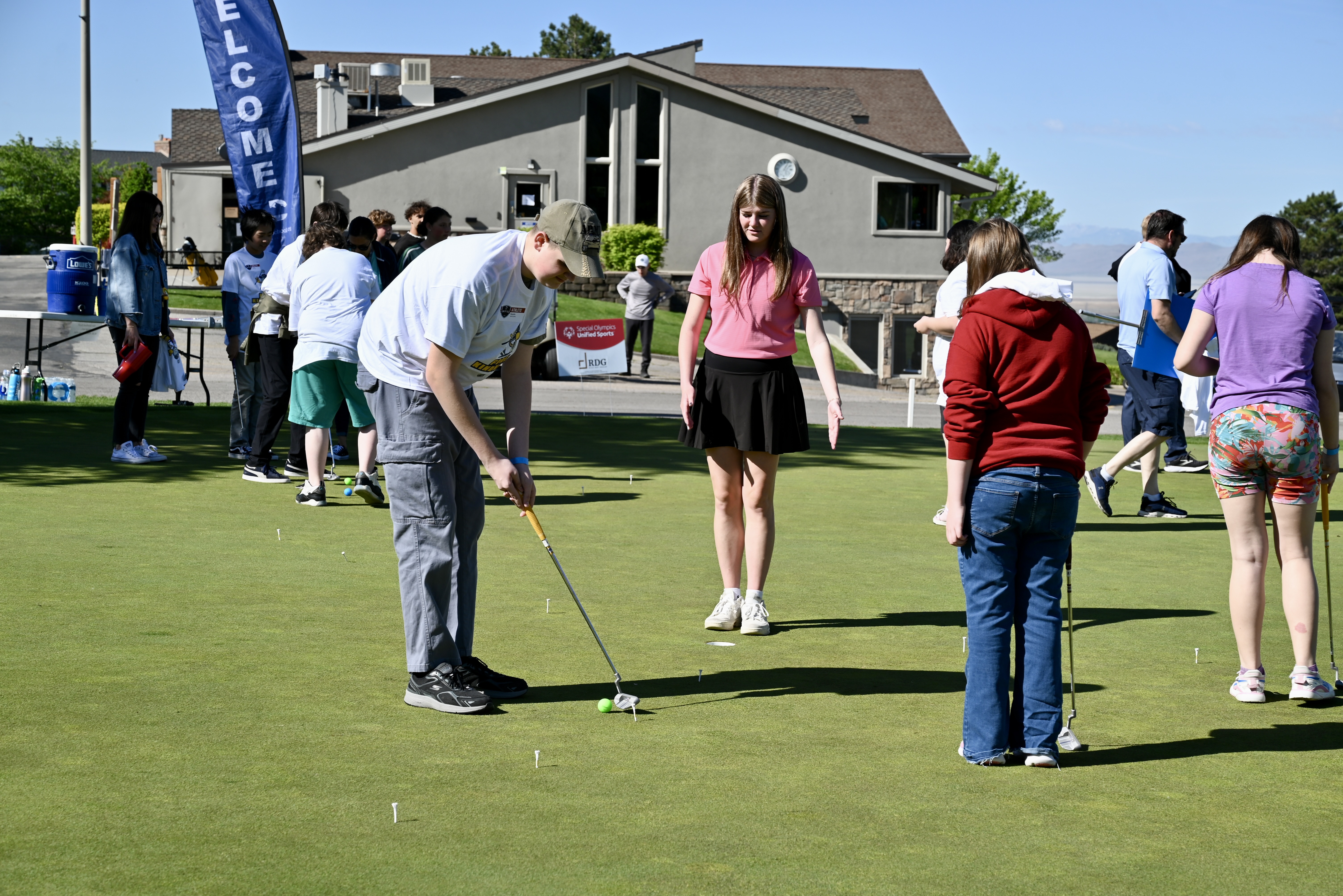 Students putting near the Valley View clubhouse with a welcome banner