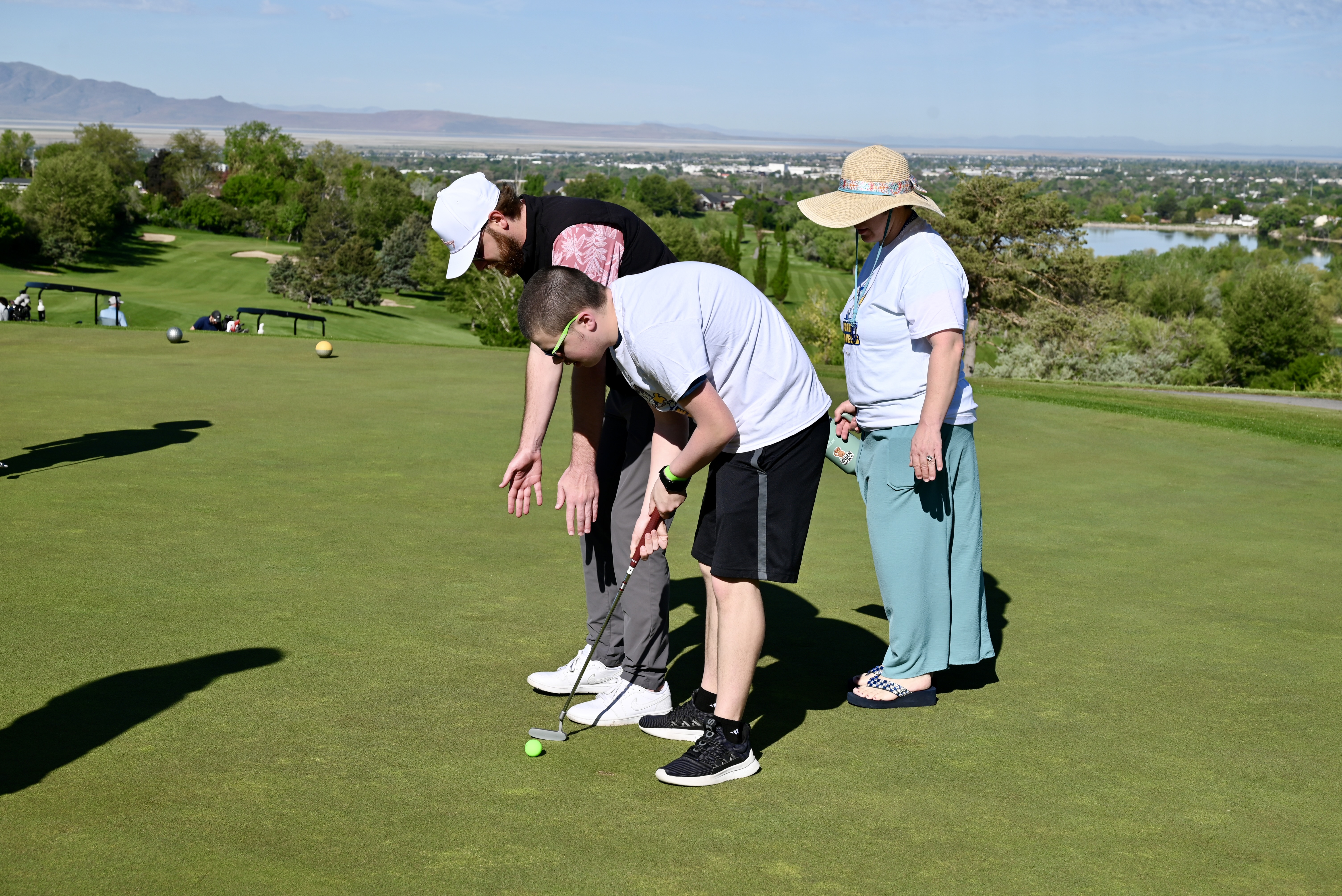 Putting instruction on a hilltop green overlooking the valley