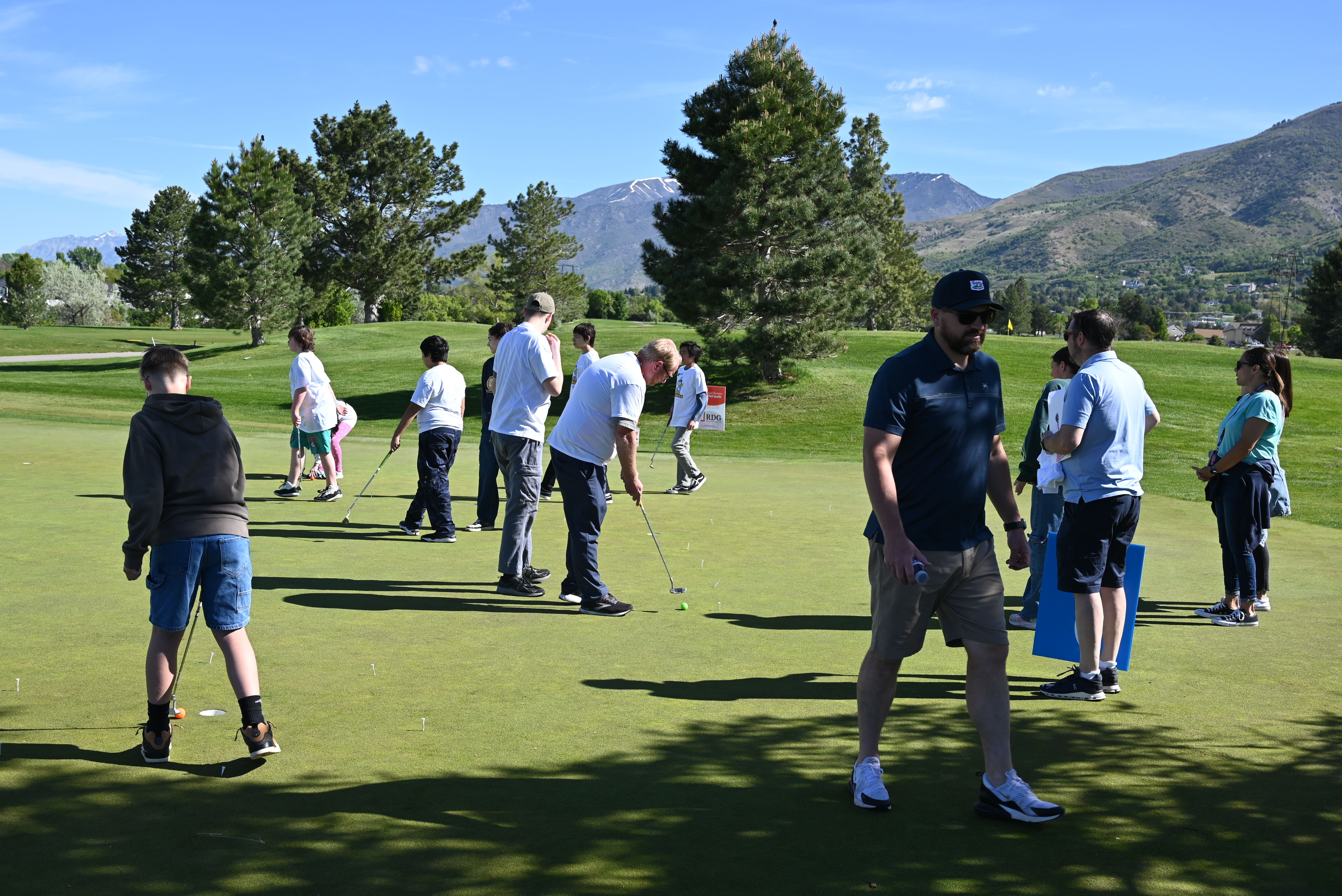 Students on the putting green with mountain scenery