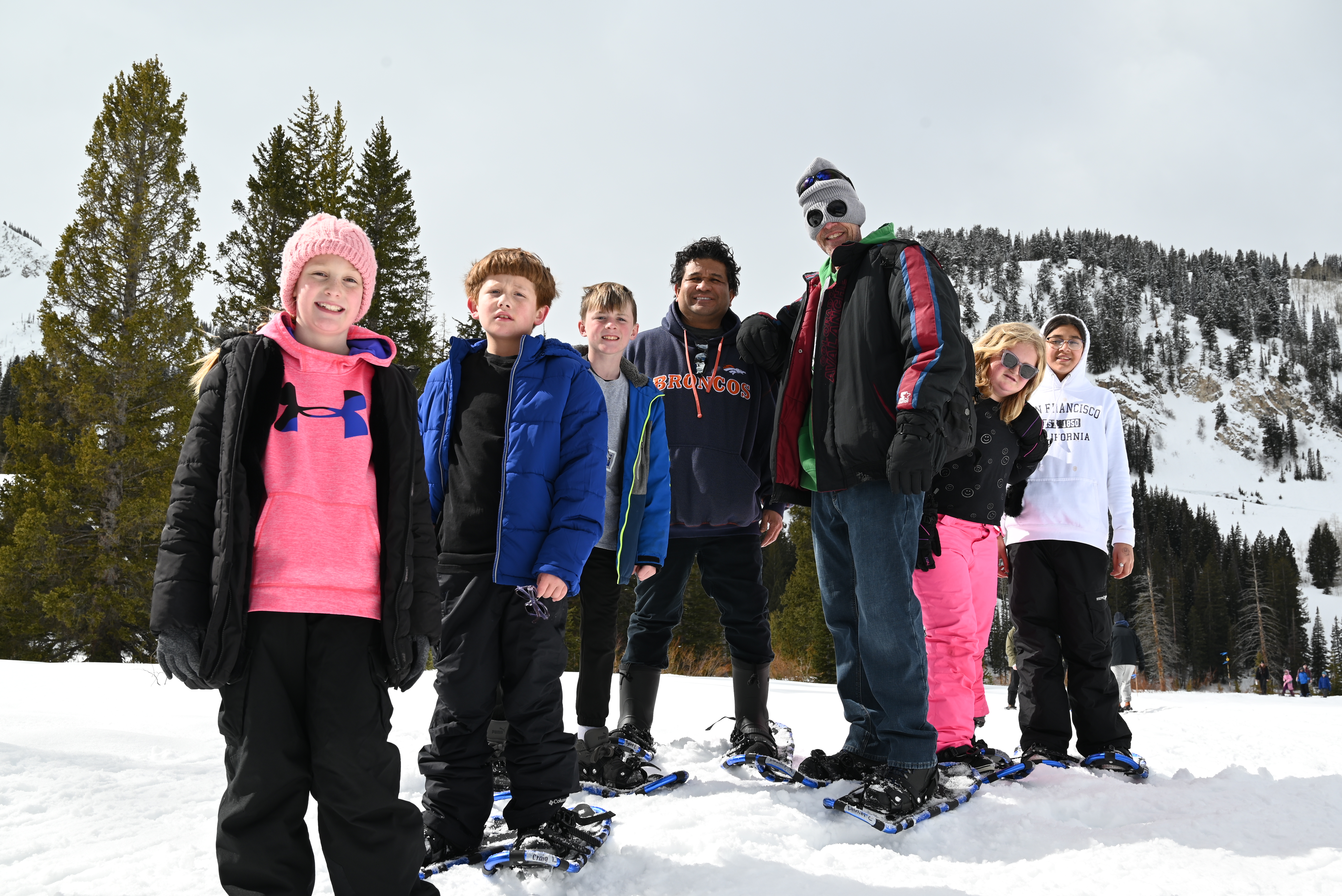 Group photo of students in snowshoes with mountains in the background