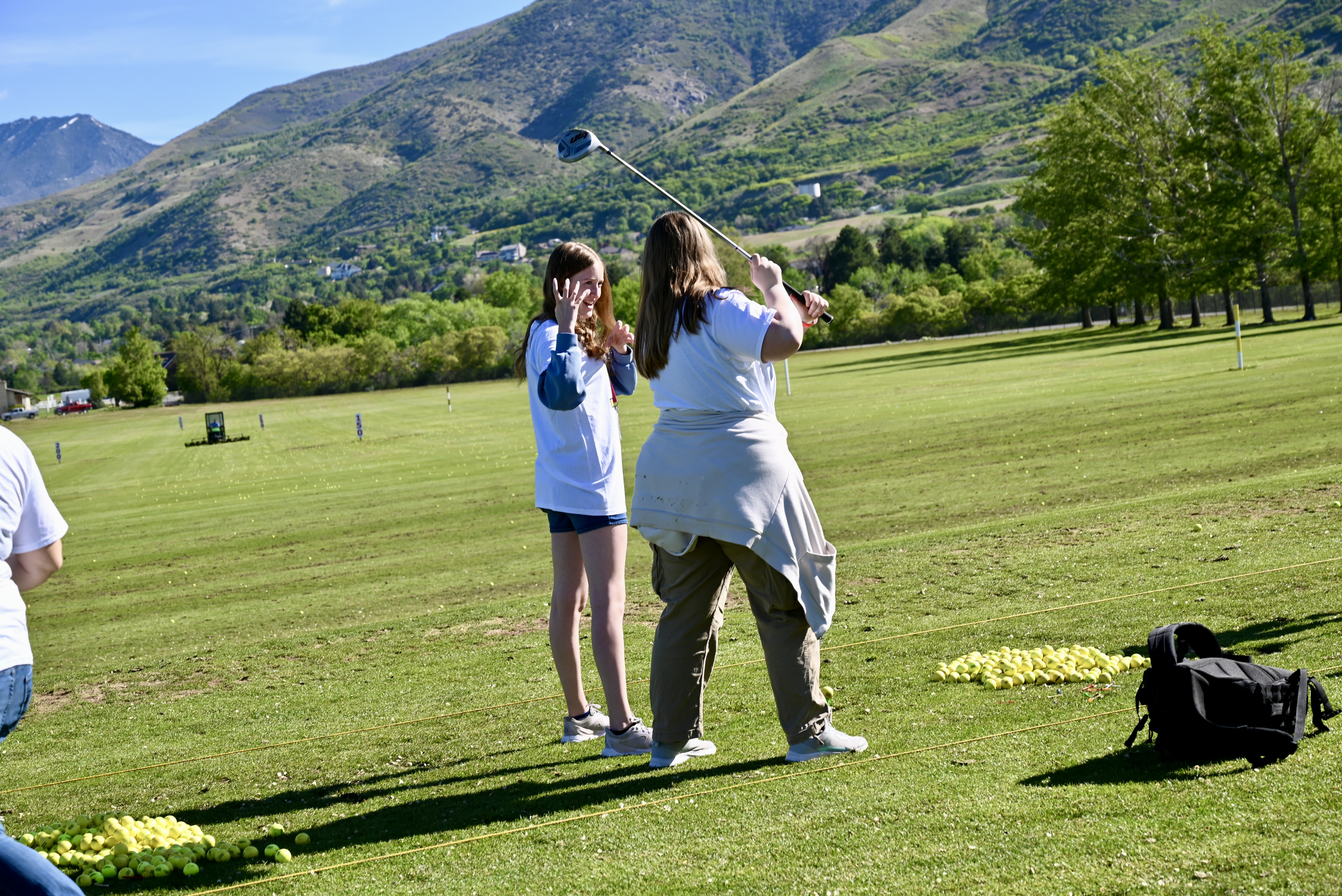 A student takes a driving lesson with mountains in the background
